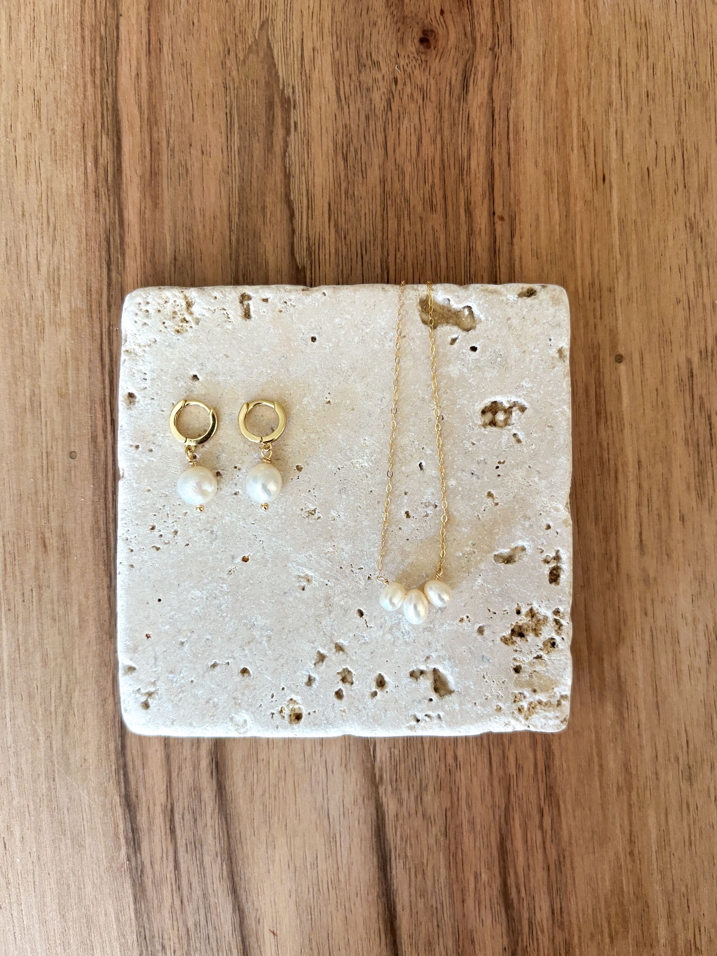 Boucles d'oreilles et collier perles sur travertin